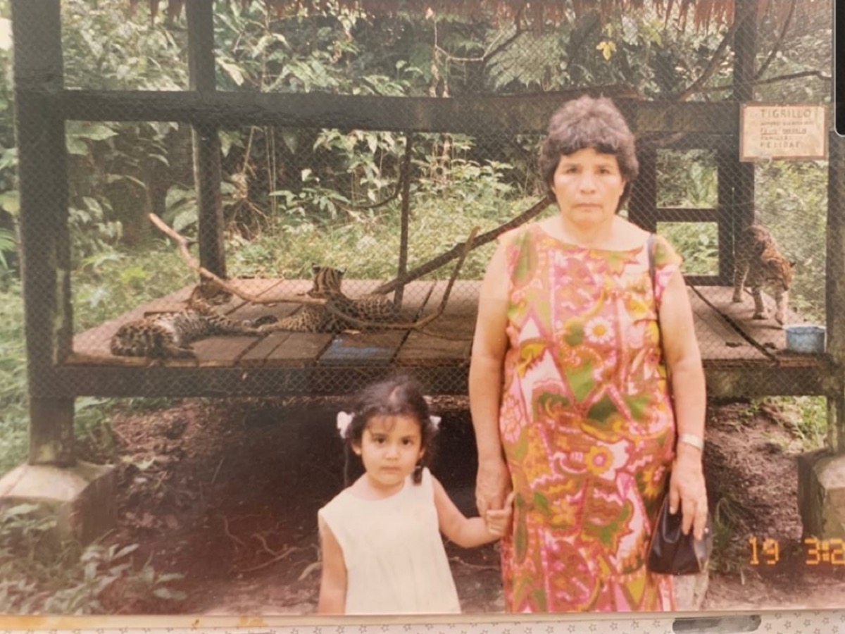 an old photo of a grandmother and her grand daughter holding hands in front of a zoo cage of tigers